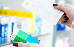 closeup hand of woman pharmacist with prescription and medicine at drugstore